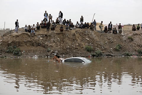 File picture from Sanaa shows volunteers trying to retrieve a car submerged under flood waters.