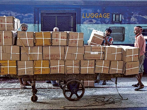 Porters load goods onto a train at a railway station. A Ludhiana girl's only clue that her father was a porter helped reunite her with her parents.