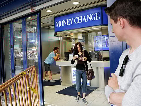 Claire Hunt, center, of Reading, England, changes pounds for dollars, at a money exchange in New York.