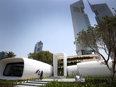 Two women pass the world’s first functional office building made using 3D printer technology in Dubai