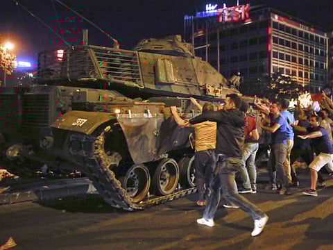 People react near a military vehicle during an attempted coup in Ankara, Turkey, July 16, 2016. The failed coup led to more than 250 deaths.