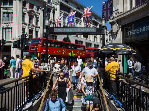Pedestrians and commuters enter Oxford Circus Underground station in London, UK. The British economy has fallen into recession after official figures Wednesday showed it contracting by a record 20.4% in the second quarter as a result of lockdown measures.