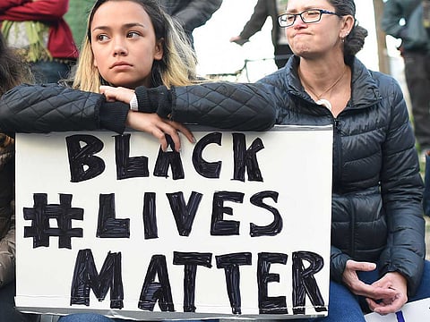People take part in a rally for the Black Lives Matter movement at Justin Herman Plaza in San Francisco, California