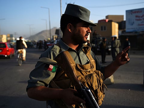 An Afghan police guard near the site of an explosion, in Kabul