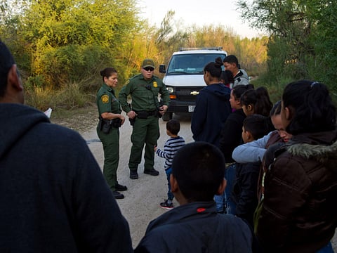 U.S. Border Patrol agents speak to suspected immigrants near the U.S.-Mexico border in McAllen, Texas.