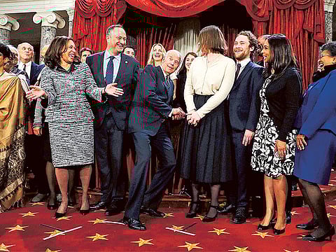 Vice-President Joe Biden (centre) ducks down so all of the family of Senator Kamala Harris (second right) can be seen for a group photo during a mock oath ceremony.