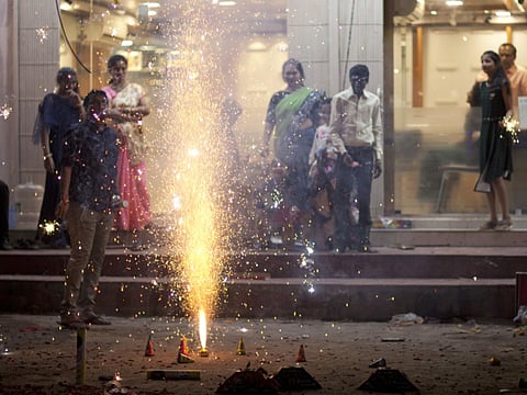 Indian people plays with firecrackers to celebrate Diwali, the Hindu festival of lights, in Hyderabad, India, Thursday, Oct. 19, 2017. Hindus light lamps, wear new clothes, exchange sweets and gifts and pray to goddess Lakshmi during Diwali, the festival of lights. (AP Photo/Mahesh Kumar A.)