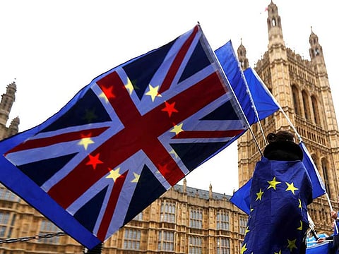 Anti-Brexit protesters wave EU and Union flags outside the Houses of Parliament in London