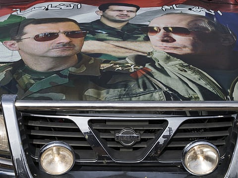 A car covered in a collage showing portraits of Russian President Vladimir Putin, right, Syrian President Bashar Assad, left, and President's Assad brother, Gen. Maher Assad, in Maarzaf, about 15 kilometers west of Hama, Syria.