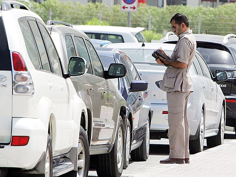 An employee of RTA issues fine to a vehicle in Al Safa area of Dubai.