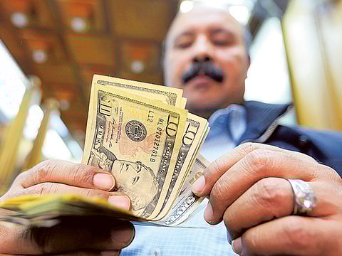 Illustrative image: A man counts U.S dollars at a money exchange office in central Cairo