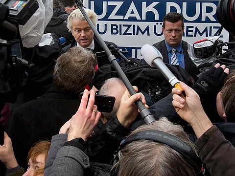 Campaign staff hold a banner reading "Stay Away, This Is Our Country" as firebrand lawmaker Geert Wilders, left, protests in The Hague, Netherlands earlier this year