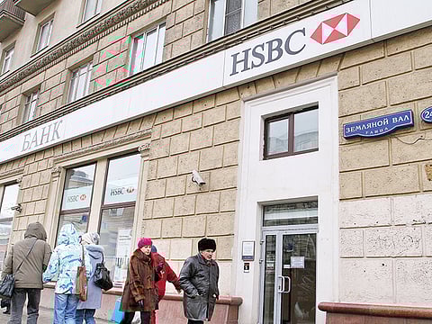 Pedestrians pass an HSBC Holdings Plc bank branch.