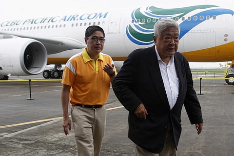 File: Philippines' largest flag carrier Cebu Pacific Air President and CEO Lance Gokongwei (L) walks with his father John Gokongwei.