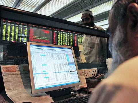 A Pakistani trader monitors share prices at the Karachi Stock Exchange