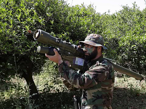 A Hezbollah militant is seen standing at attention in an orange field near the town of Naqura on the Lebanese-Israeli border in this file picture.
