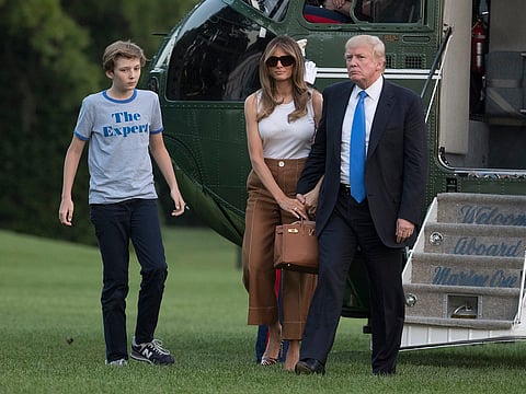 President Donald Trump, first lady Melania Trump, and their son, Barron Trump, walk from Marine One across the South Lawn to the White House in Washington, Sunday, June 11, 2017.