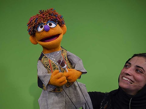 Afghan puppeteer holds new Sesame Street Muppet 'Zeerak' during a recording at a television studio in Kabul.