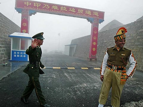 This file photo taken on July 10, 2008 shows a Chinese soldier (L) next to an Indian soldier at the Nathu La border crossing between India and China in India's northeastern Sikkim state.