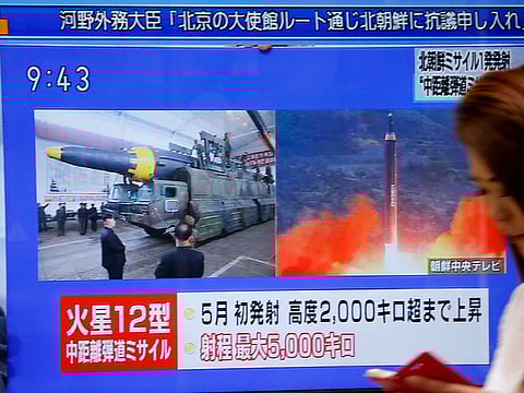 A woman walks past a TV screen broadcasting news of North Korea's missile launch, in Tokyo, Tuesday, August 29, 2017.