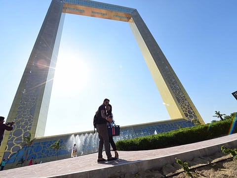 People taking picture with Dubai Frame.