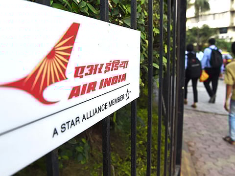 Pedestrians walk past a sign of state carrier Air India outside its headquarters in Mumbai. The building has been sealed for two days after an employee tested positive for COVID-19.