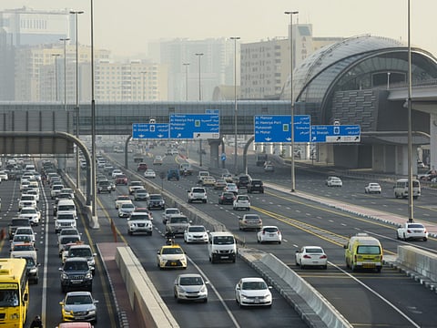 Morning rush hour traffic from Sharjah to Dubai near Al Qiyada metro station.