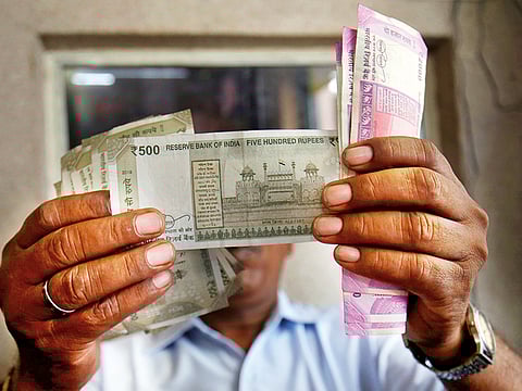 Illustrative image: A cashier checks Indian rupee notes inside a room at a fuel station in Ahmedabad, India.