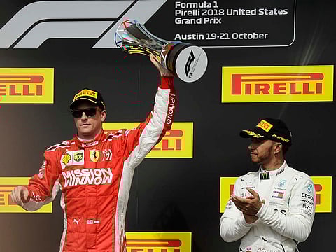 Ferrari driver Kimi Raikkonen, of Finland, holds the trophy after winning the Formula One U.S. Grand Prix auto race at the Circuit of the Americas, Sunday, Oct. 21, 2018, in Austin, Texas. Mercedes driver Lewis Hamilton, right, of Britain, finished third.
