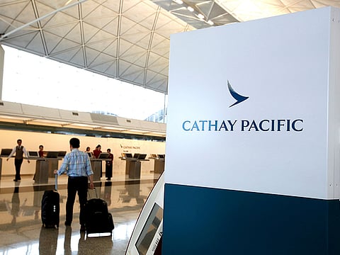 A passenger walks to the First Class counter of Cathay Pacific Airways at Hong Kong Airport in Hong Kong.