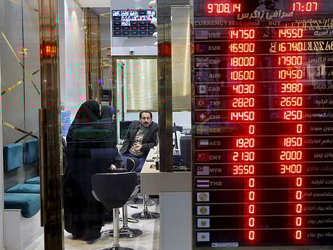 Customers speak to a money exchange staff in downtown Tehran.