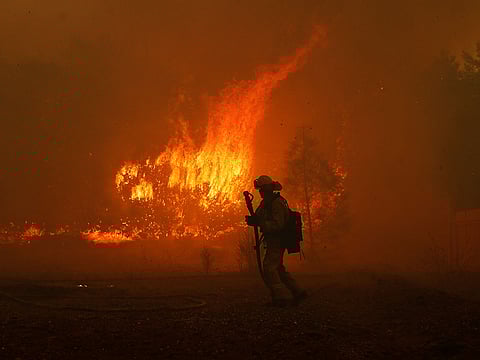 A Cal Fire firefighter monitors a fire near a home while battling the Camp Fire in Paradise, California, U.S. November 8, 2018.