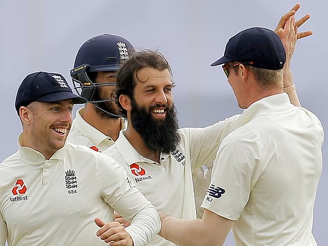 England's Moeen Ali (centre) celebrates the dismissal of Sri Lanka's Niroshan Dickwella with team mates during the fourth day of the first test cricket match in Galle, Sri Lanka.