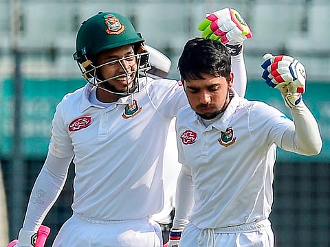 Bangladesh's Mominul Haque (R) celebrates his century with Mushfiqur Rahim (L) during the first day of the second Test cricket match against Zimbabwe at the Sher-e-Bangla National Cricket Stadium in Dhaka on November 11, 2018.