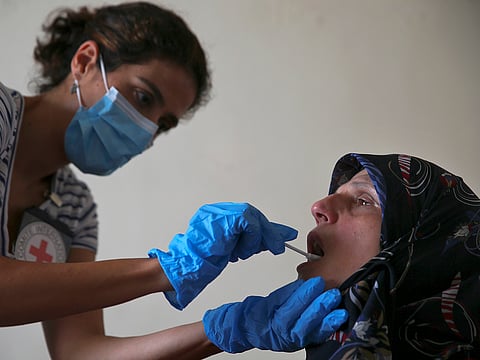 A member of The International Red Cross takes a saliva sample from Umalbaneen Ali Wehbe, sister of Habib Ali Wehbe who went missing in 1976 during the Lebanese civil war, at her home, in the southern suburb of Beirut Beirut, Lebanon.