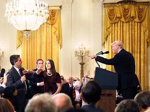 A White House staff member reaches for the microphone held by CNN's Jim Acosta as he questions US President Donald Trump during a news conference following Tuesday's midterm US congressional elections at the White House in Washington, on November 7, 2018. R
