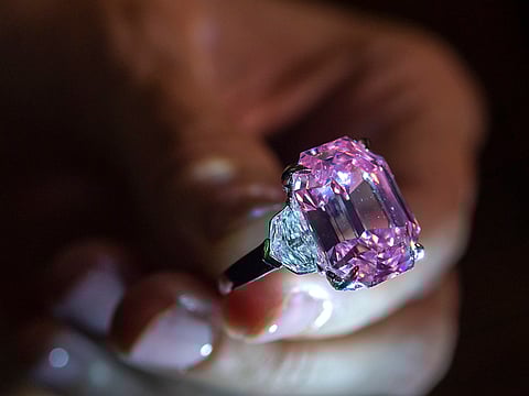 A Christie's employee displays an 18.96-carat fancy vivid pink diamond during a preview at Christie's in Geneva, Switzerland.