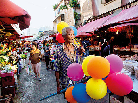 A street vendor sells balloons at an open market in Bangkok, Thailand.