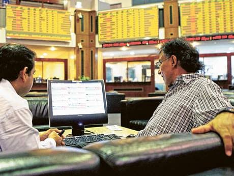 Investors follow stock market activity at the Dubai Financial Market