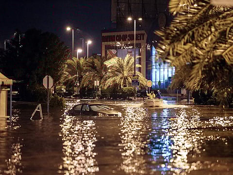 People are having fun with a boat on the flooded main road of the Daeya area of Kuwait city late on November 14, 2018, following heavy rain in the Gulf emirate, four days after flash floods hit the Gulf emirate, killing a man and causing damage to roads, bridges and homes