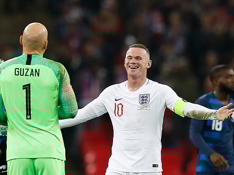 England's Wayne Rooney, right, jokes with Unites States goalkeeper Brad Guzan.