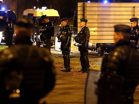 French police look on as some protesters stand on the side of a road in Reims on November 17, 2018, at the end of a nationwide popular initiated day of protests called the "yellow vest" (Gilets Jaunes in French) movement to protest against high fuel prices which has mushroomed into a widespread protest against stagnant spending power under French President. More than 120 000 people were taking part in more than 2000 protests at roundabouts and motorway exits, Interior Minister said. Most protests were relatively calm despite the anger expressed by many in interviews and on social media in recent days over the surge in fuel prices this year, in particular for diesel.