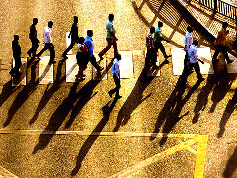 Pedestrians cross a road in Dubai. According to data, four Dubai communities together have a population size of 609,513 individuals and represent 17.88 per cent of the total population size of the emirate.