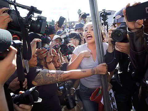An anti-migrant demonstrator is surrounded by the press as she argues with a woman during a protest against the presence of thousands of Central American migrants in Tijuana, Mexico, on November 18, 2018.