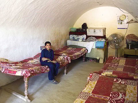 A young Pakistani villager sits in a cave room in Nikko village, about 60 kilometres from the capital Islamabad.