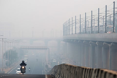 Vehicles traveling along a road as a train traveling along a section of an elevated track are shrouded in smog in Delhi, India, on Friday, Nov. 9, 2018. Air pollution levels skyrocketed in New Delhi and left India's capital shrouded in toxic smog as millions of Indians set off firecrackers for Diwali, the Hindu festival of lights. Toxic air is estimated to kill more than 1 million Indians each year, according to the nonprofit Health Effects Institute. Photographer: Ruhani Kaur/Bloomberg