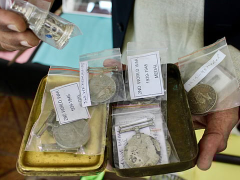Riaz Malik showing world war medals and coins