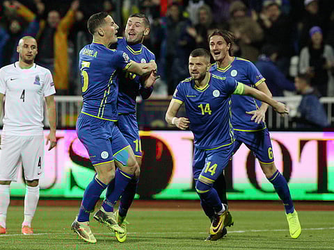Kosovo's Arber Zeneli celebrates scoring their first goal with teammates.