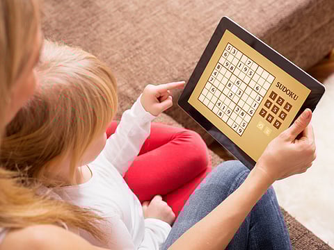 Parent using a tablet, but playing an educational game