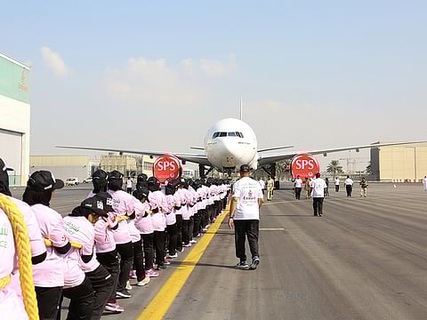 Dubai Police women officers pull a Boeing 777-300R.